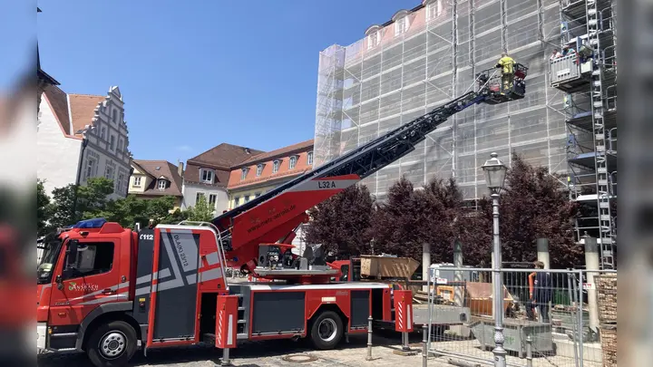 Mit der Drehleiter holte die Ansbacher Feuerwehr die zwei unfreiwillig pausierenden Bauarbeiter aus rund zwölf Metern Höhe herunter.  (Foto: Jonas Volland)