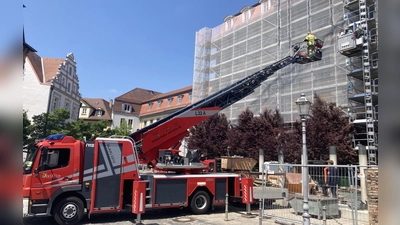 Mit der Drehleiter holte die Ansbacher Feuerwehr die zwei unfreiwillig pausierenden Bauarbeiter aus rund zwölf Metern Höhe herunter.  (Foto: Jonas Volland)