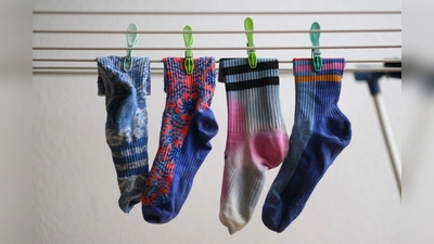 Bunte Socken hängen auf einem Wäscheständer. Am 9. Mai ist Tag der verschwundenen Socken. (Foto: Robert Michael/dpa)