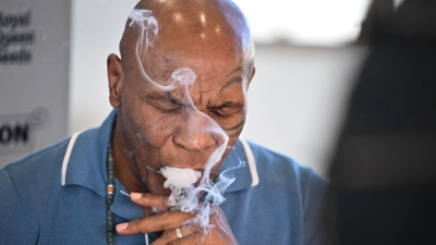 Box-Ikone und Cannabis-Unternehmer Mike Tyson raucht an einem Stand der Cannabis-Messe Mary Jane einen Joint.  (Foto: Sebastian Gollnow/dpa)
