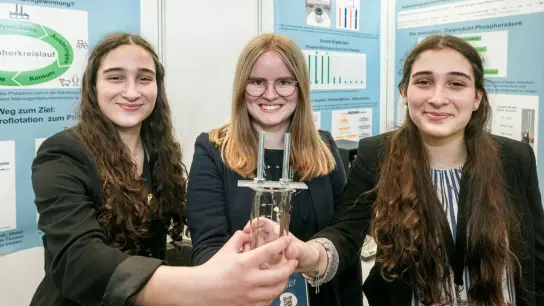 Die Chemie-Bundessiegerinnen Lena Fries (l-r), Hannah Amrhein und Hanna Fries halten ihr Forschungswerkzeug, ein Becherglas mit Elektroden. (Foto: Markus Scholz/dpa)