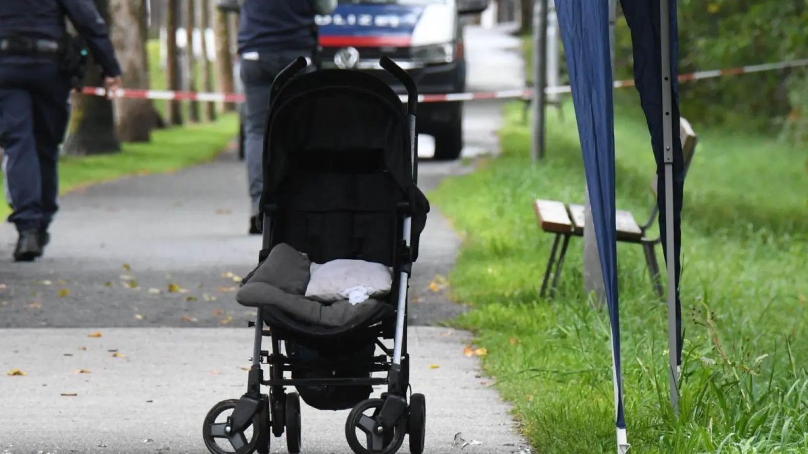 Polizisten ermitteln an einem Abgesperrten Bereich eines Gehwegs, auf dem eine Kinderkarre steht. Sechs Monate nach dem Ertrinkungstod eines Sechsjährigen in Österreich steht sein Vater unter dringendem Mordverdacht. (Foto: Georg Köchler/Zoom Tirol/APA/dpa)