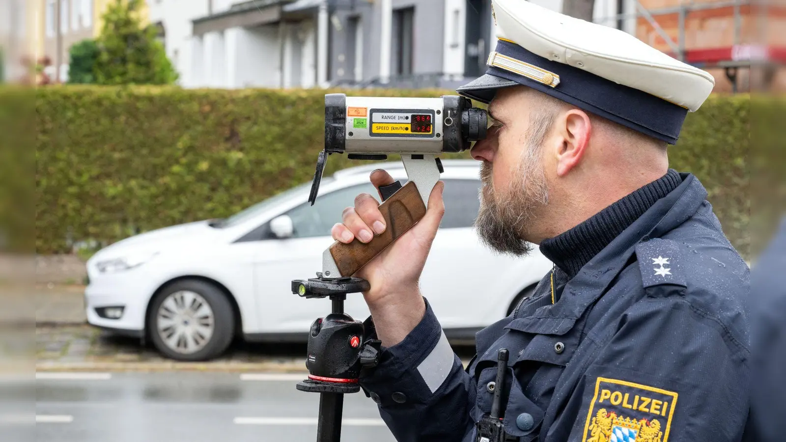 Ein Polizeibeamter schaut durch ein Messgerät zur Geschwindigkeitskontrolle. (Foto: Pia Bayer/dpa)
