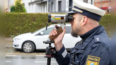 Ein Polizeibeamter schaut durch ein Messgerät zur Geschwindigkeitskontrolle. (Foto: Pia Bayer/dpa)