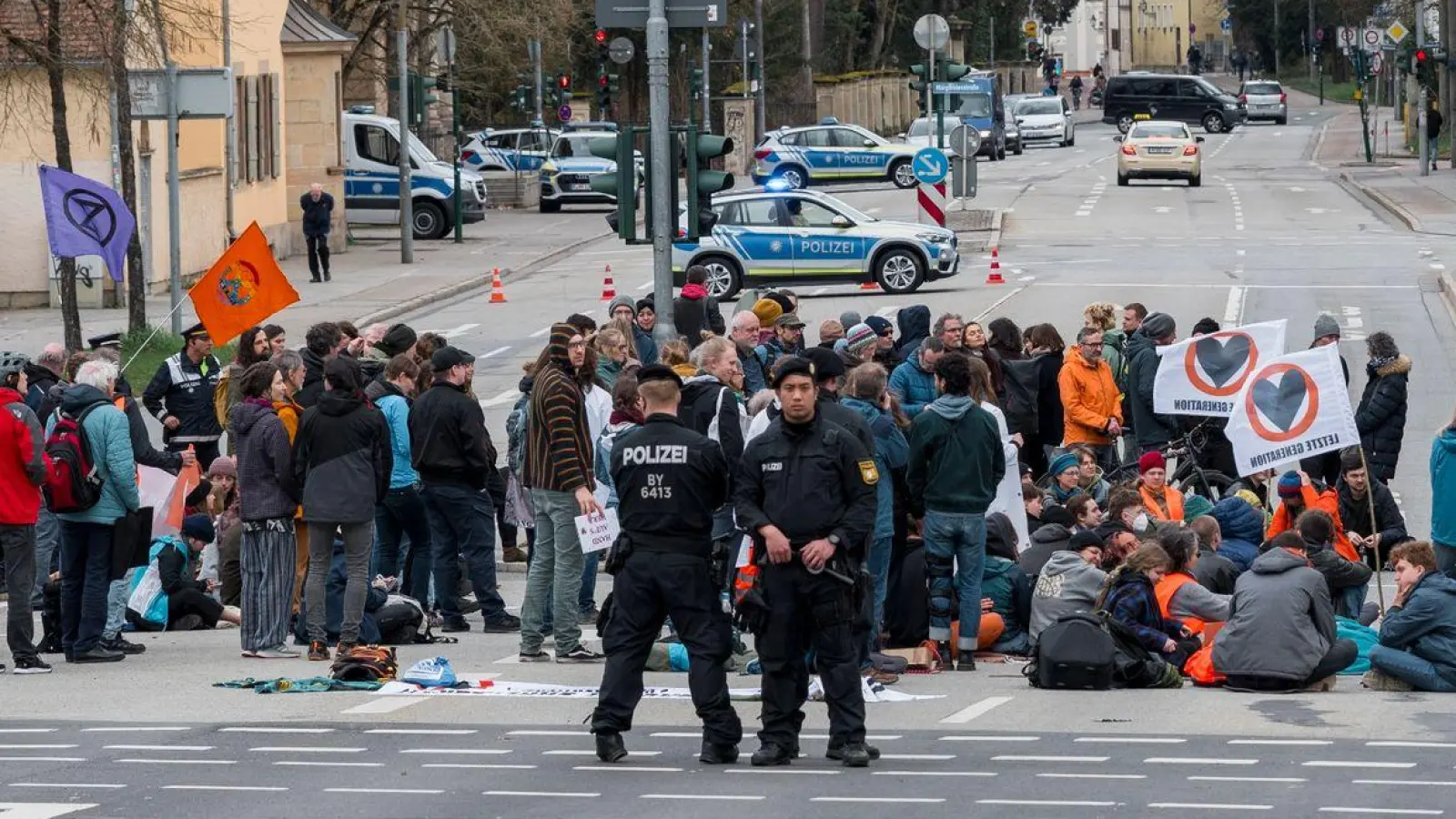 Aktivistinnen und Aktivisten der Letzten Generation blockieren eine Kreuzung in Regensburg. (Foto: Daniel Vogl/dpa)