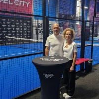 Mit Leidenschaft und Freude zum Sport: Evi und Stefan Glanz stehen in ihrer Halle vor dem Padel-Court. (Foto: Leonie Lang)