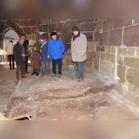Das Dach ist fertig, jetzt geht es im Inneren des Klosterchors weiter. Dort untersucht derzeit der Archäologe Wolfgang Steeger (rechts) den Untergrund. Hier zeigt er den Gästen den von ihm jüngst freigeelgten Altar. (Foto: Gerhard Krämer)