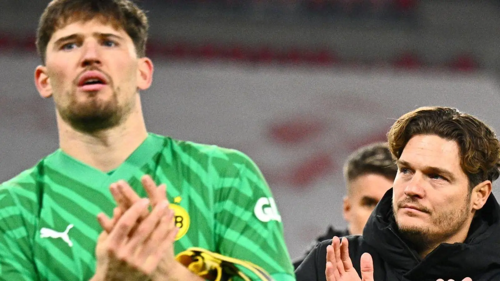 Dortmunds Torwart Gregor Kobel (l) und Trainer Edin Terzic verabscheden sich nach dem Pokal-Aus von den Fans. (Foto: Tom Weller/dpa)