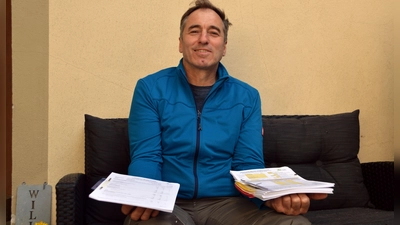 Jürgen Dierauff zeigt den Papierkrieg, den er Düngemeldung für Düngemeldung machen muss – links der Stapel, der künftig wegfällt, und rechts jener, der bleibt. (Foto: Johannes Zimmermann)