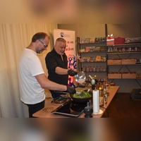 Schriftsteller Peter Denlo (rechts) bot in der Feuchtwanger Stadtbücherei bei der Lesung seines Buchs „Zungentod – Ein Burma-Krimi mit Rezepten“ auch etwas für den Gaumen. Beim Kochen am Wok bekam er mit Oliver Keil (links) Unterstützung aus dem Publikum.  (Foto: Erich Herrmann)