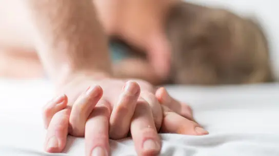 Ein junges Paar liegt im Bett. Laut einer Studie verändert sich unsere Atenzusammensetzung je nach emotionalem Zustand. (Foto: Christophe Gateau/dpa)