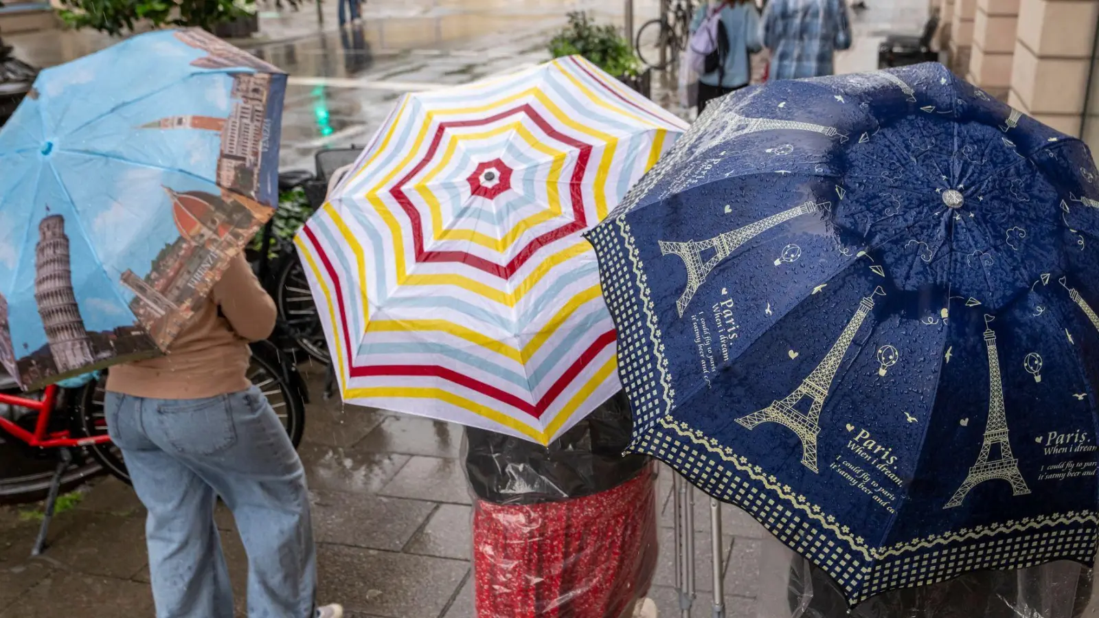 Bei Regenwetter und Schauern bleibt der Regenschirm ein wichtiges Accessoire.  (Foto: Peter Kneffel/dpa)