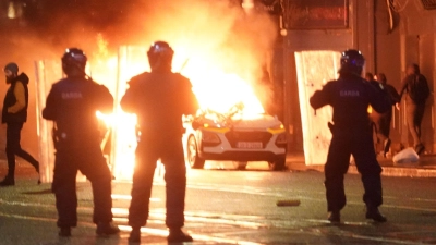 In der Nähe des Tatorts kam es am Abend zu schweren Ausschreitungen. Dabei wurde auch ein Polizeiauto in Brand gesetzt. (Foto: Brian Lawless/PA Wire/dpa)