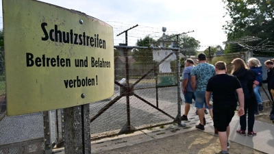 Besucher besichtigen am Tag der Deutschen Einheit die Reste von Mauer und Stacheldraht im Deutsch-Deutschen Museum Mödlareuth. (Foto: Martin Schutt/dpa)