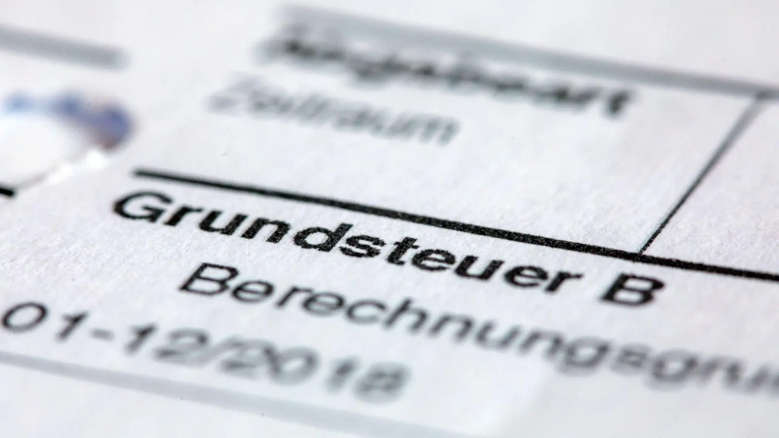 Ein Abgabenbescheid für die Entrichtung der Grundsteuer. (Foto: Jens Büttner/dpa)