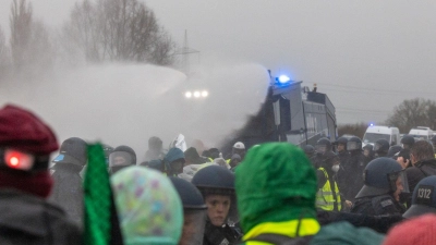 Die Polizei setzt Wasserwerfer gegen Demonstranten ein, die die B429 nahe der Lahnbrücke blockieren.  (Foto: Lando Hass/dpa)