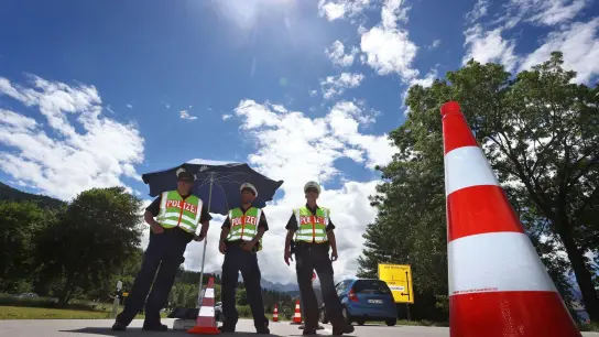 Polizisten stehen bei einer Verkehrskontrolle am Ortseingang. (Foto: Karl-Josef Hildenbrand/dpa)