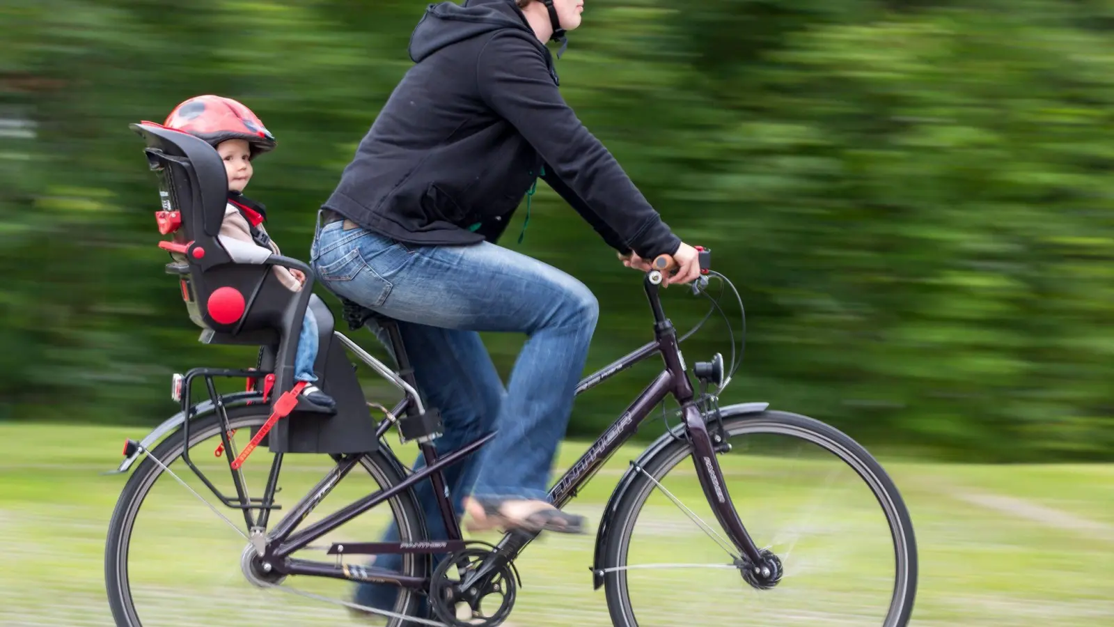 Vorbildlich radeln: Mit passendem Kindersitz - und nicht nur der Nachwuchs trägt Helm. (Foto: Michael Reichel/dpa-Zentralbild/dpa-tmn)