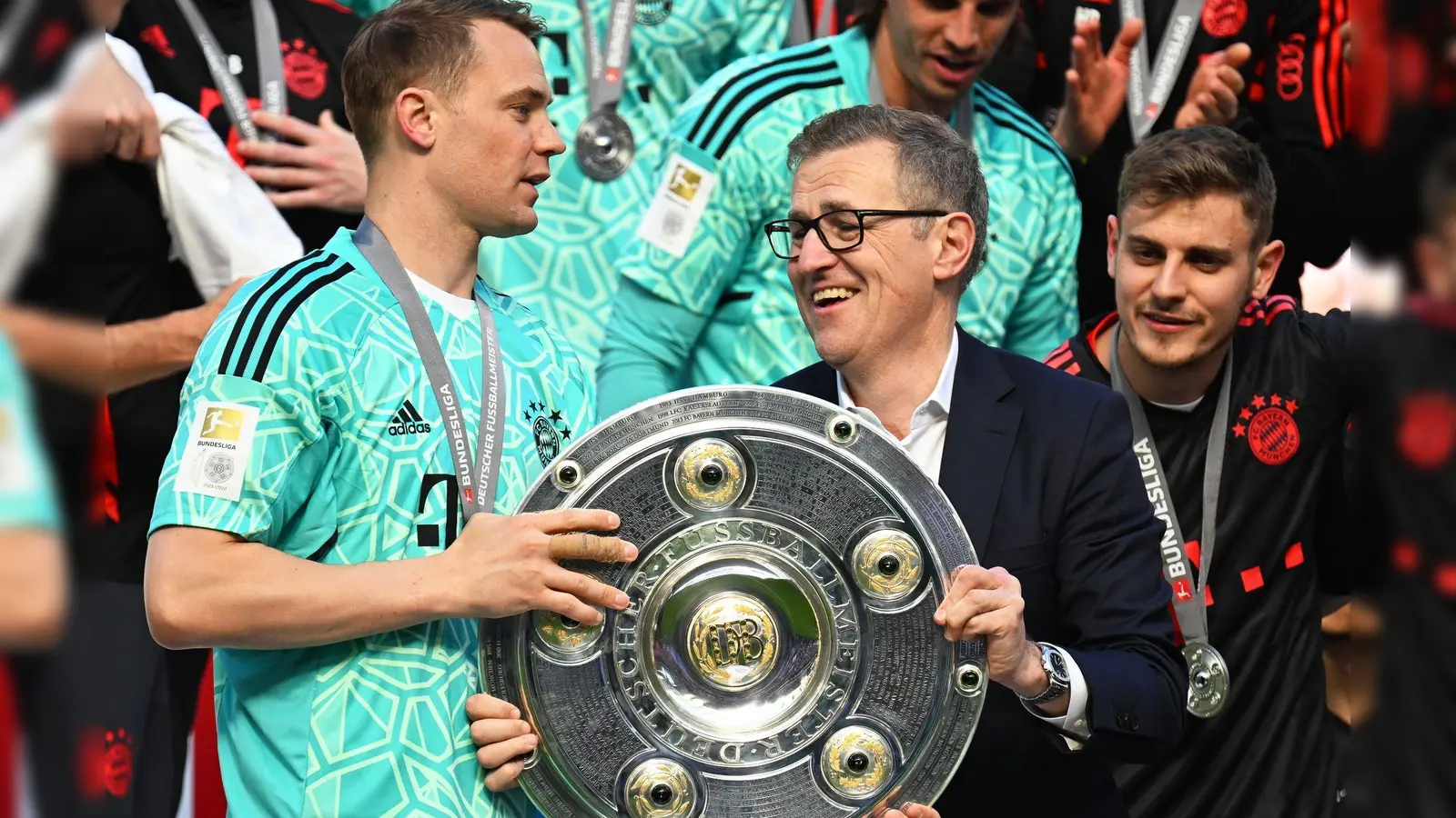Manuel Neuer (l) erhielt 2023 die Meisterschale von DFL-Vertreter Jan-Christian Dreesen (M). (Foto: Federico Gambarini/dpa/Archiv)