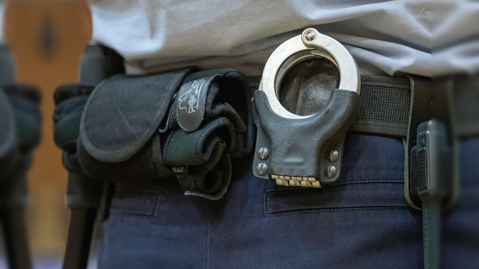 Handschellen stecken in der Gürtelhalterung eines Justizbeamten. (Foto: Friso Gentsch/dpa/Symbolbild)