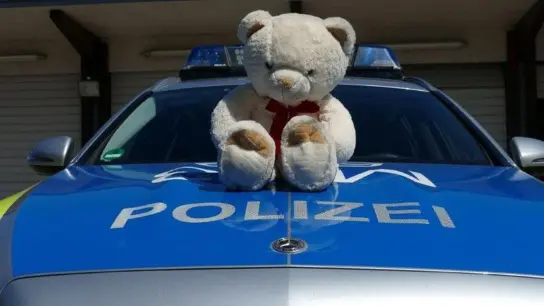Ein auf der Autobahn 6 gefundener Teddybär sitzt auf einem Polizeiauto. Die Beamten haben das Stofftier nach einer Rettungsaktion zurückgegeben. (Foto: -/Polizei Mannheim/dpa)