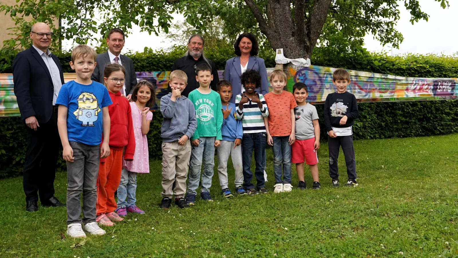 Jürgen Lößlein, Dr. Jürgen Ludwig, Stefan Lang und Katja Wiehl (von links) mit einigen Schülerinnen und Schülern des Förderzentrums. Das Graffiti-Banner im Hintergrund entstand in einem Projekt mit der Mittelschule. (Foto: Simone Hedler)