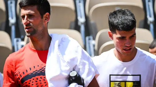 Novak Djokovic (l) aus Serbien und Carlos Alcaraz aus Spanien gehen nebeneinander während einer Trainingseinheit für die French Open 2023. (Foto: Matthieu Mirville/ZUMA Press Wire/dpa)