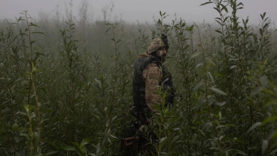 Ein ukrainischer Marinesoldat geht durch ein Gelände an der Frontlinie nahe des Flusses Dnepr. (Foto: Alex Babenko/AP/dpa)