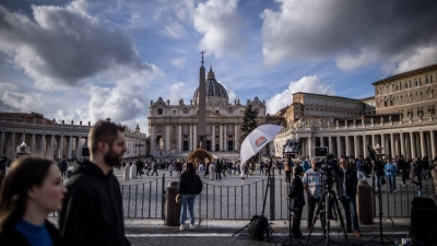 Touristen, Gläubige und Journalisten stehen vor dem Petersdom in der Vatikanstadt. (Foto: Oliver Weiken/dpa)