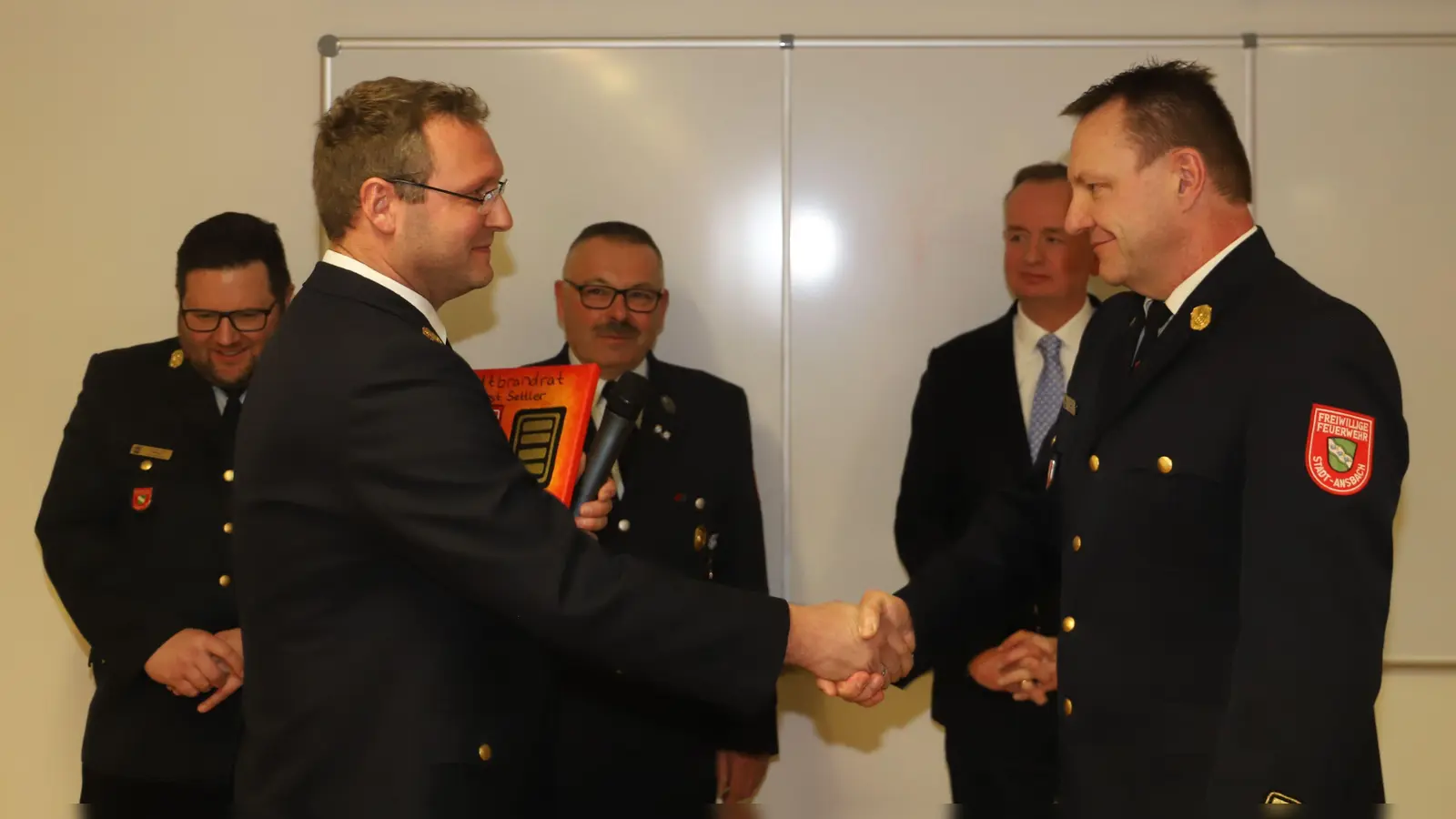 Ein symbolischer Händedruck des neuen Stadtbrandrats Steffen Beck (vorne links) und seines Vorgängers Horst Settler: Mit dabei waren Stadtbrandinspektor Tilman Wörrlein, der geschäftsführende Vorsitzende Klaus Schwarzbeck und OB Thomas Deffner (hinten von links). (Foto: Oliver Herbst)