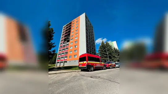 Einsatzfahrzeuge stehen vor dem Wohnhaus, in dem ein Feuer im fünften Stock ausgebrochen war. (Foto: Alexandra Motková/TASR/dpa)