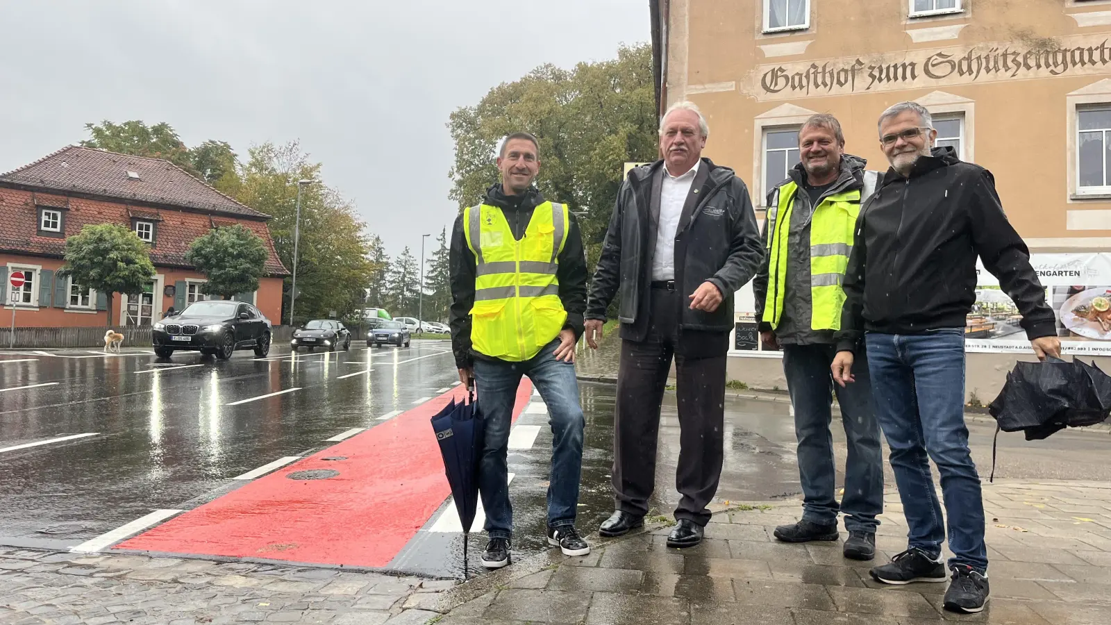 Trotz des Regens ließen es sich Jörg Wellhöfer (links) und Bernd Trapp (Dritter von links) von der Tiefbauabteilung der Stadt sowie Bauamtsleiter Gerald Schorr (rechts) nicht nehmen, gemeinsam mit Bürgermeister Klaus Meier die sanierte Nürnberger Straße „einzuweihen“.<br> (Foto: VOLKER RAAB)