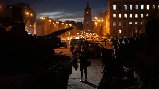Eine Frau steht vor einer Ausstellung zerstörter russischer Panzer und gepanzerter Fahrzeuge in der Kiewer Innenstadt. (Foto: Daniel Cole/AP/dpa)