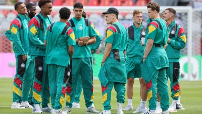 Die deutschen Spieler auf dem Stadionrasen nach der Ankunft.  (Foto: Jan Woitas/dpa)