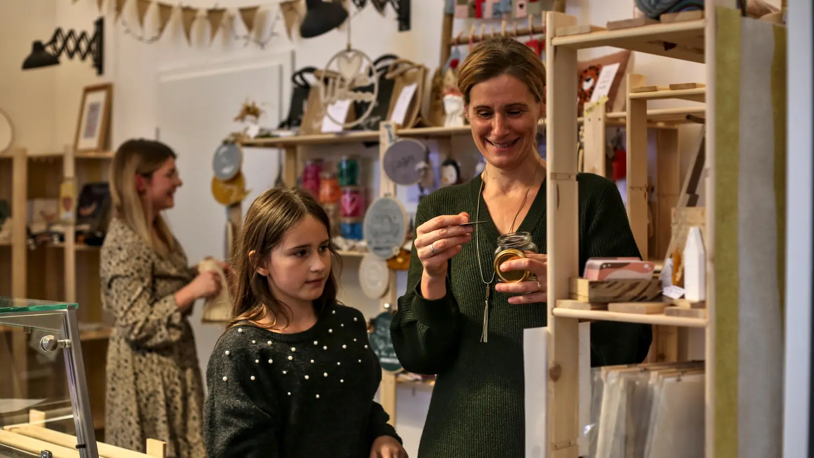 Die Künstlerin Marion Weigel richtet mit Tochter Karla ihr Regal für den Verkauf ein. Im Hintergrund beginnt auch Stefanie Fronczek mit dem Bestücken der Holzauslagen. (Foto: Tizian Gerbing)