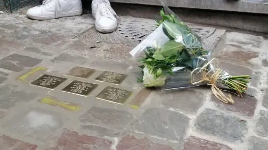 Ein Blumenstrauß liegt am internationalen Holocaust-Gedenktag neben sogenannten „Stolpersteinen“, die an Opfer des Holocaust erinnern sollen. (Foto: Gabriel Mitran/BELGA/dpa/Symbolbild)