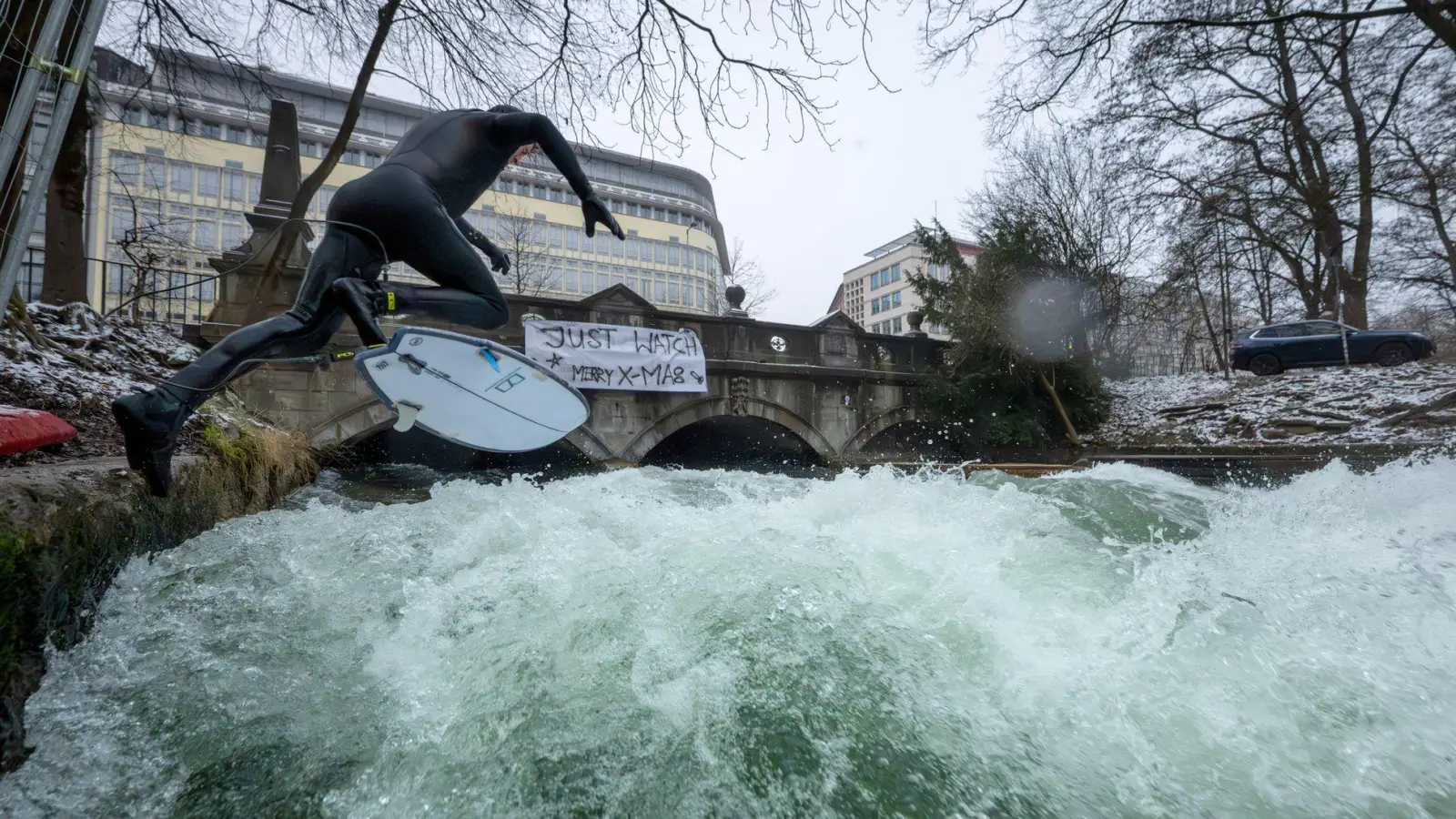 Ein Mann versucht mit einem großen Sprung auf die provisorische Eisbachwelle im Englischen Garten zu springen. Seit dem ersten Weihnachtstag können Surfer wieder auf der stehenden Welle reiten, nachdem sich die Welle in den vergangenen zwei Monaten nicht mehr aufgebaut hatte. Die Welle ist normalerweise zu jeder Jahres- und Tageszeit ein wahrer Hotspot für Touristen und Surfer aus der ganzen Welt. (zu dpa: «Eisbachwelle: Surfer und Stadt einigen sich auf Pilotversuch») (Foto: Peter Kneffel)