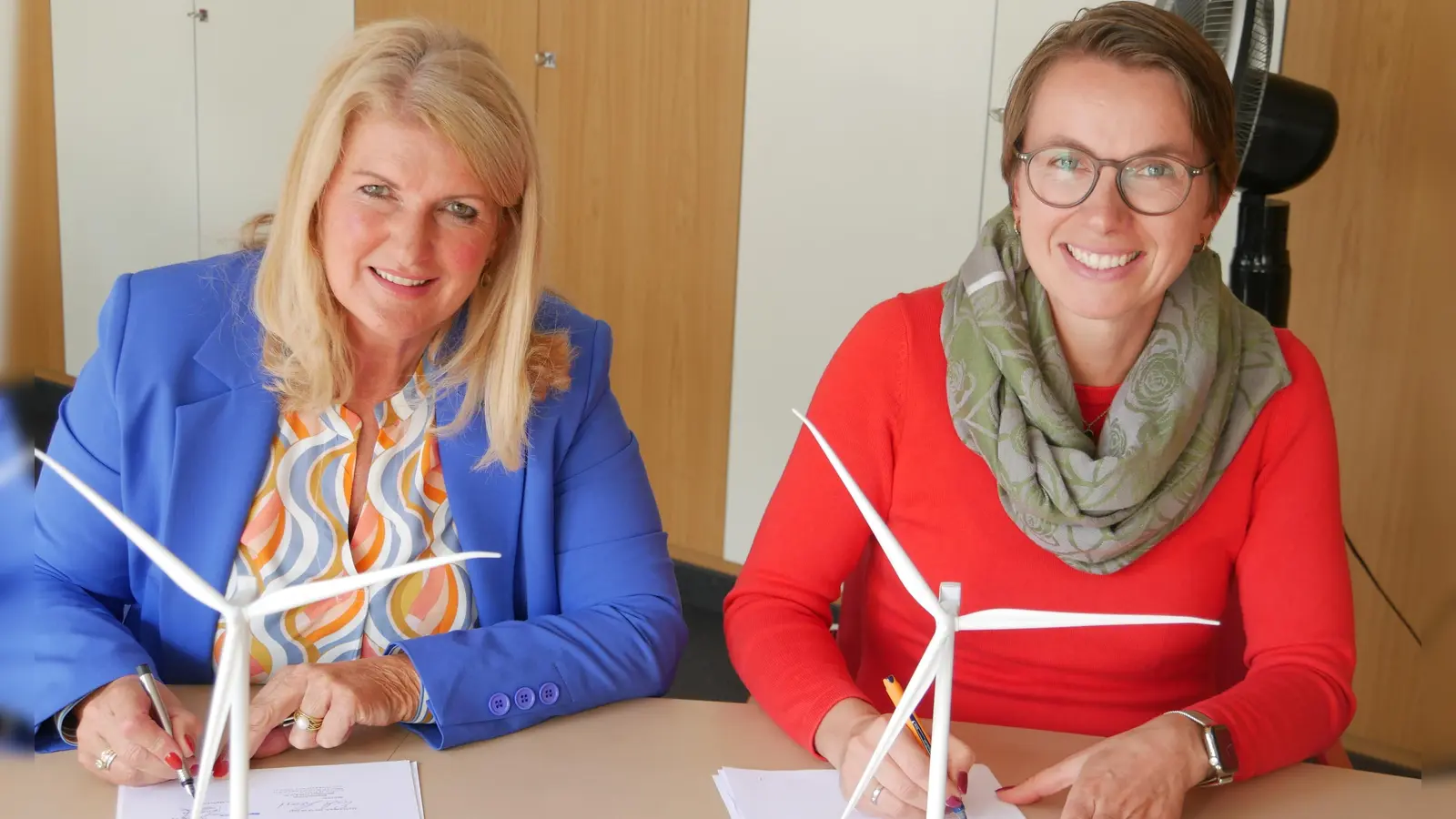 Bürgermeisterin Birgit Kreß (links) und Nadine Paulus unterschreiben eine Vereinbarung, die der Gemeinde 0,2 Cent pro produzierter Kilowattstunde Strom sichert. (Foto: Ulli Ganter)