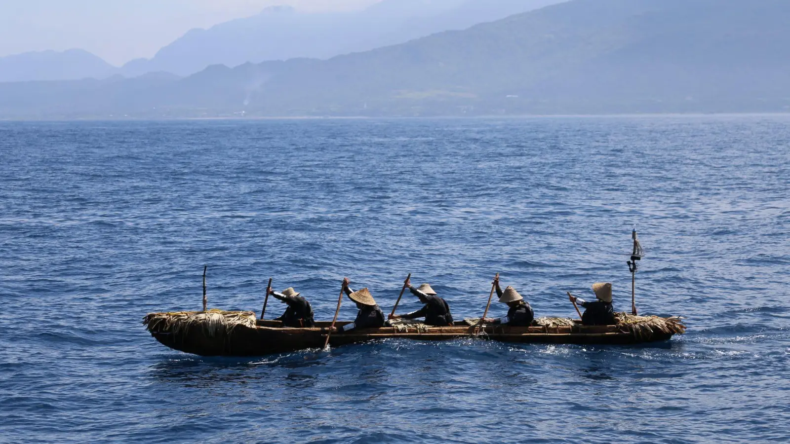 Forscher paddeln mit einem selbstgebauten Kanu über das Wasser.  (Foto: Yousuke Kaifu/dpa)