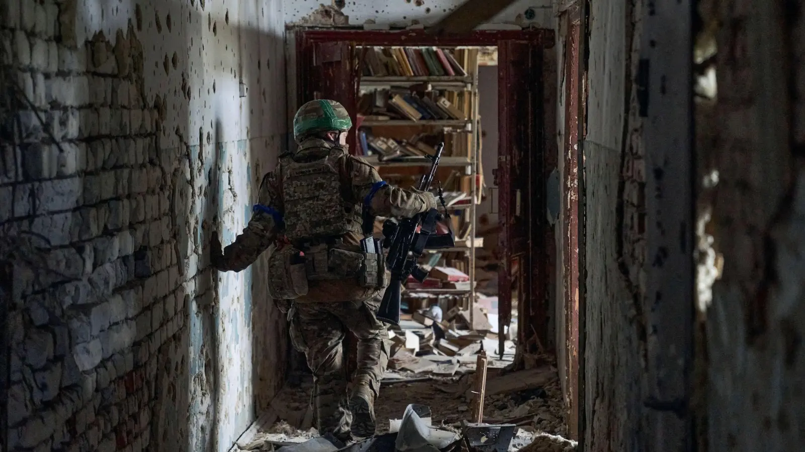 Ein ukrainischer Soldat inspiziert ein Haus in dem kürzlich zurückeroberten Dorf Blahodatne in der Region Donezk. (Foto: LIBKOS/AP/dpa)