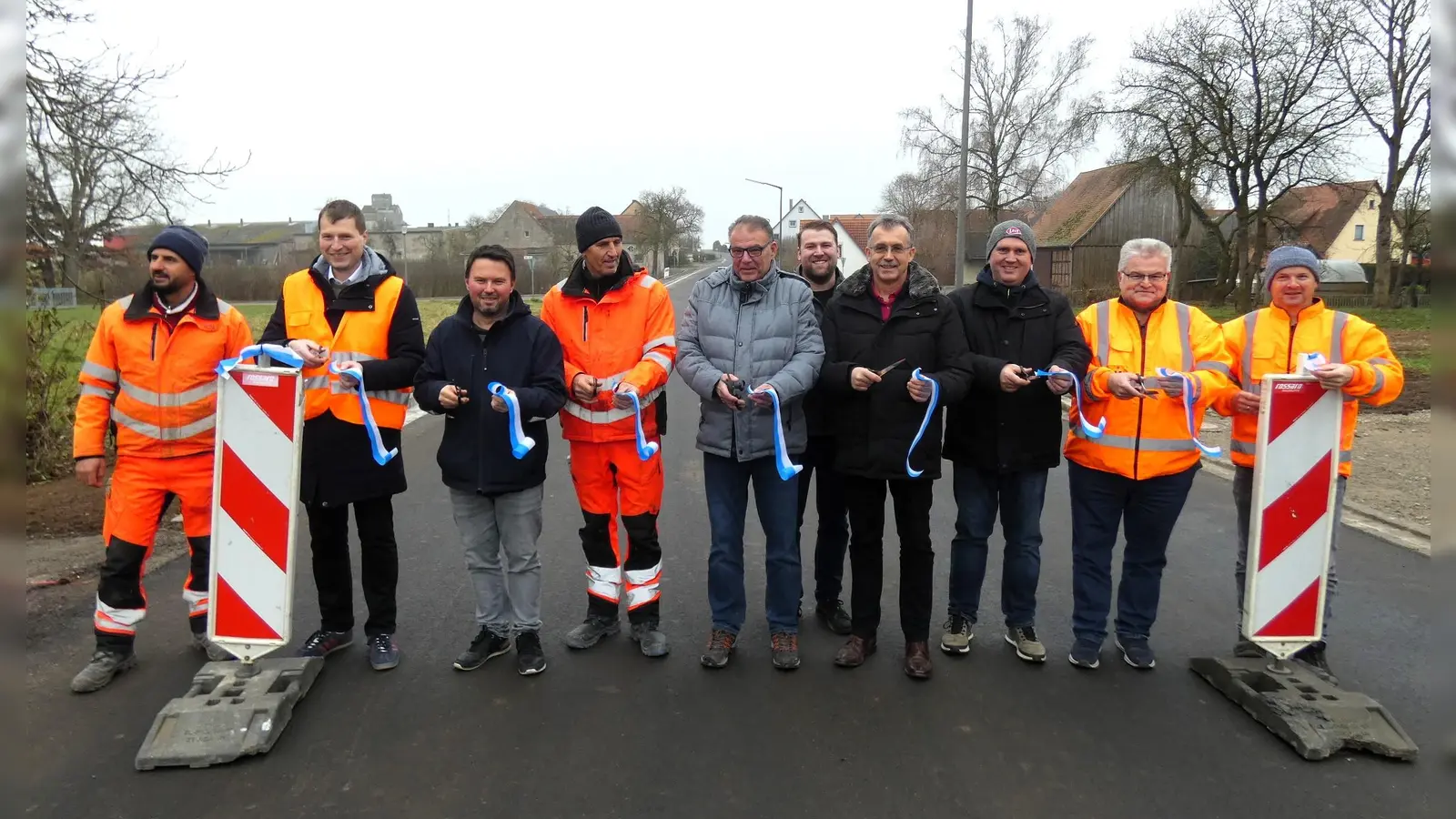 Bevor der Verkehr wieder ungehindert rollen durfte, wurde bei einem Treffen an der noch gesperrten Straße ein symbolisches Band durchschnitten. Das Foto zeigt Bürgermeister Johannes Hellenschmidt (Dritter von links) mit Vertretern des Gemeinderats, des Staatlichen Bauamts, der ausführenden Firma und des Fachbüros. (Foto: Karl-Heinz Gisbertz)