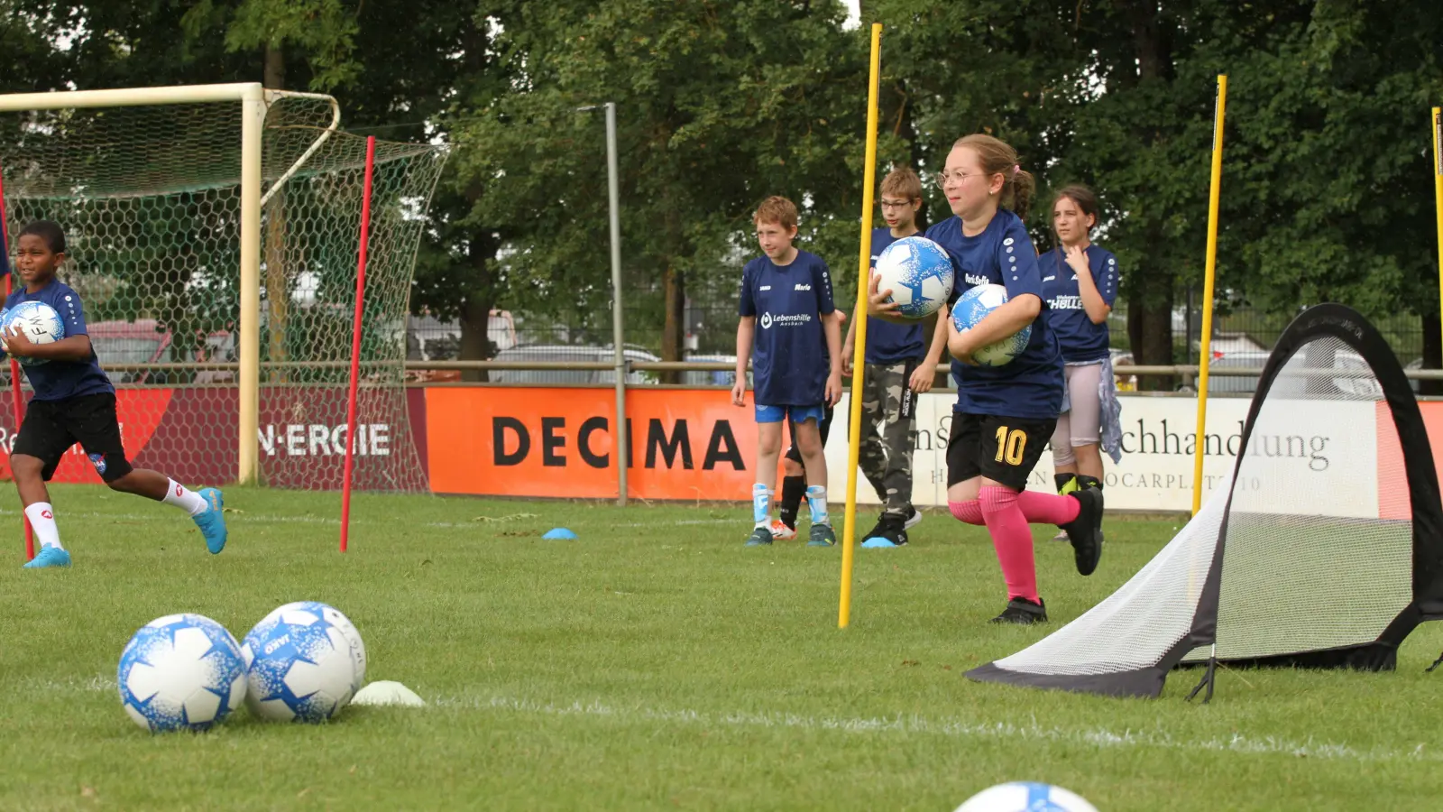 Zahlreiche Übungen, bei denen zwischen Hütchen und Stangen gedribbelt und schließlich auf ein Tor geschossen wurde, förderten den Teamgeist und den sportlichen Ehrgeiz der jungen Teilnehmerinnen und Teilnehmer. (Foto: Tizian Gerbing)