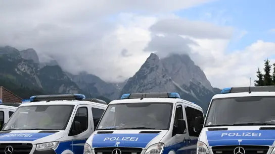Mannschaftswagen der Polizei parken in Garmisch-Partenkirchen. (Foto: Angelika Warmuth/dpa)