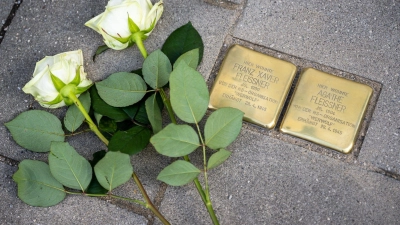 Weiße Rosen liegen neben zwei Stolpersteinen in Penzberg. (Foto: Peter Kneffel/dpa)