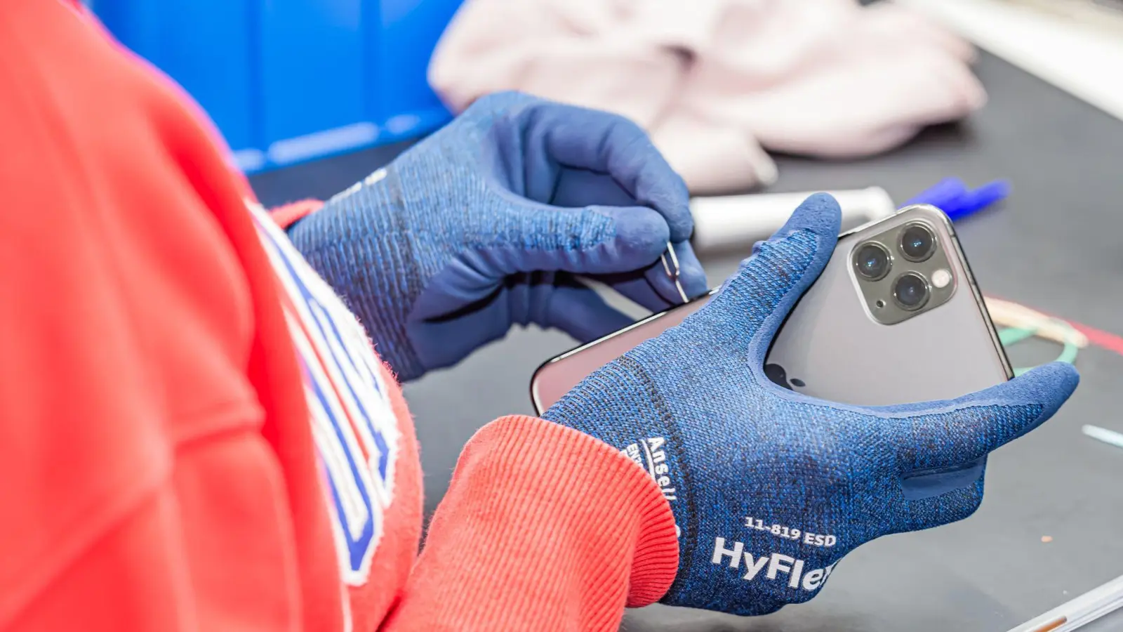 Ein Rebuy-Beschäftigter macht ein gebrauchtes iPhone flott, damit es verkauft werden kann. (Foto: -/rebuy recommerce GmbH/dpa)