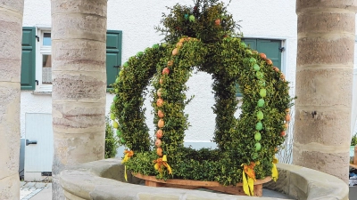 Der historische, überdachte Marktbrunnen aus dem Jahr 1544 gehört zu den Hauptsehenswürdigkeiten in Baudenbach und ist zentrales Motiv im Ortswappen. Dieses zeigt einen roten Ziehbrunnen mit Zeltdach auf grünem Grund. Anlässlich des Osterfestes wird er festlich geschmückt. (Foto: Rainer Fritsch)