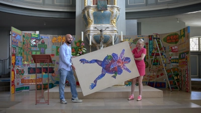 Kurator Dr. Harald Tesan und Künstlerin Petra Krischke beim Aufbau der Ausstellung „Rokokissimo“ in der St.-Gumbertus-Kirche. Krischkes Arbeiten setzen bewusst auf bunte Farben und überzeichneten Kitsch. (Foto: Tizian Gerbing)