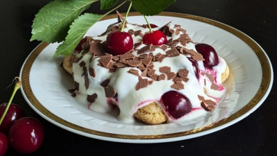 Auf die mit Espresso getränkten Löffelbiskuits kommen eine Quark-Sahne-Masse und reichlich Kirschen. Das Tiramisu wird mit Schokoraspeln getoppt.  (Foto: Doreen Hassek/hauptstadtkueche.blogspot.com/dpa-tmn)