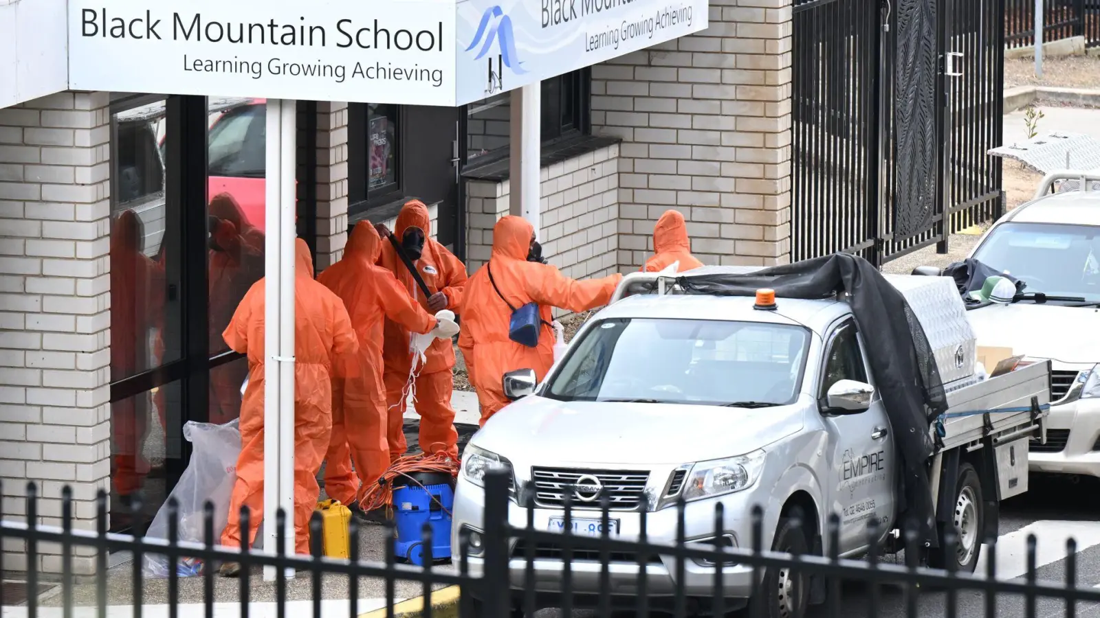In Schutzanzügen wurden die Schulen gesäubert und der Sand entsorgt. (Foto: Lukas Coch/AAP/dpa)