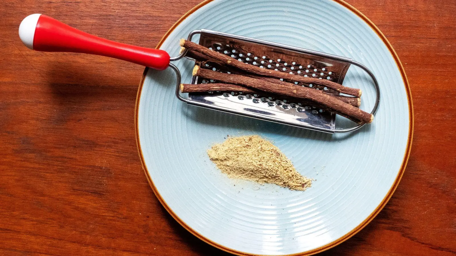 Mit einer Küchenreibe lässt sich aus den Wurzelstücken frisches Süßholzpulver raspeln. (Foto: Bernd Diekjobst/dpa-tmn)